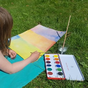 pige maler akvarel siddende på græsplæne
